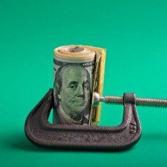 2023-11-07_Clamp_squeezing_roll_of_US_dollars_on_green.jpg